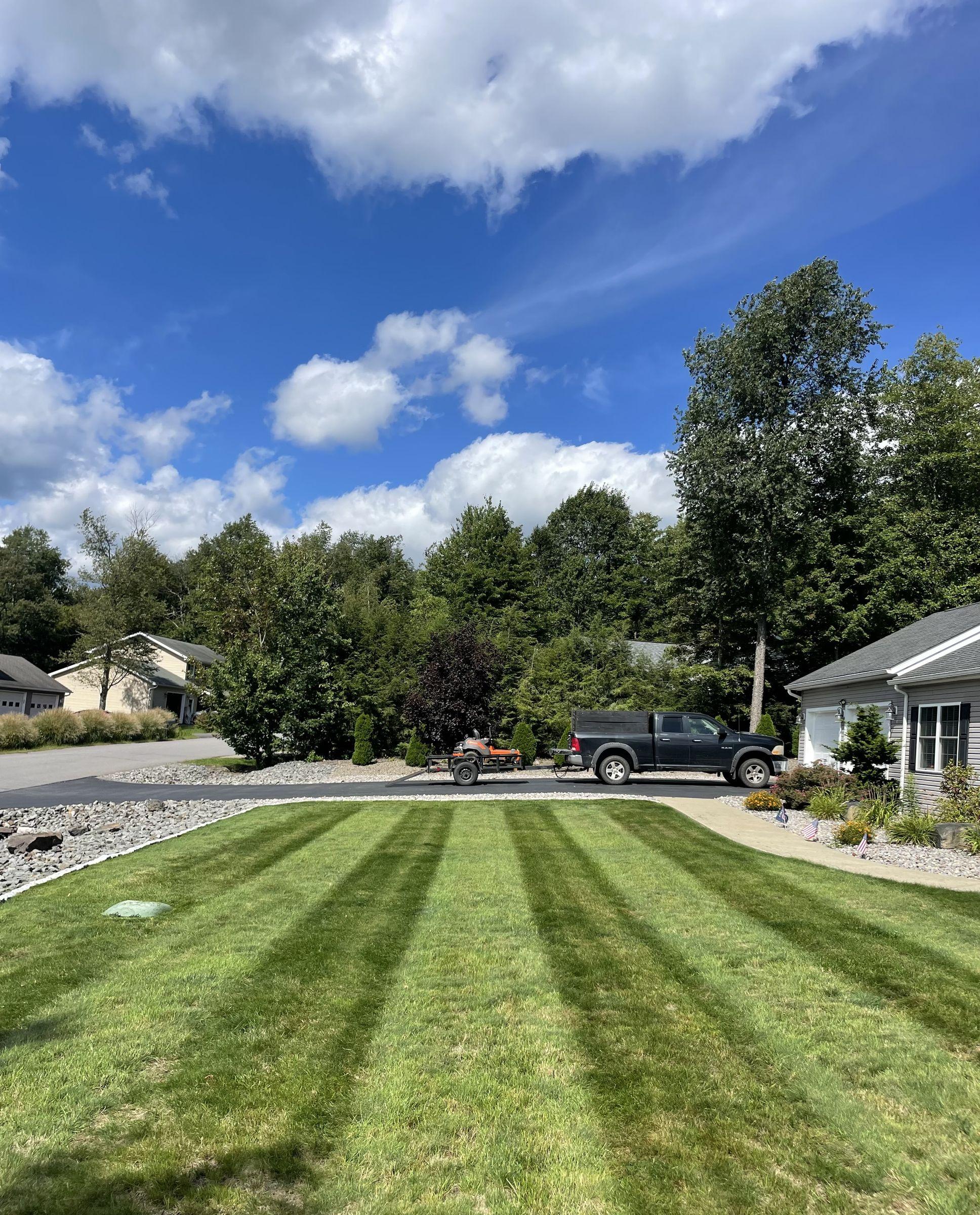 Freshly striped front lawn beside a stone-edged driveway
