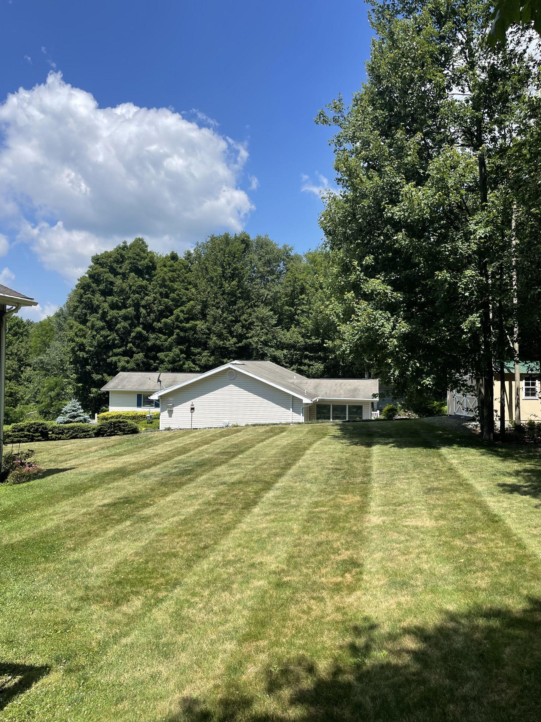 Wide striped lawn in front of a ranch home