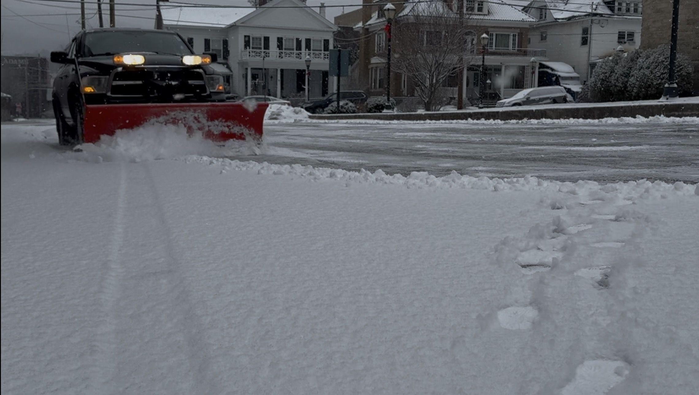 Plow truck clearing snow from a parking lot